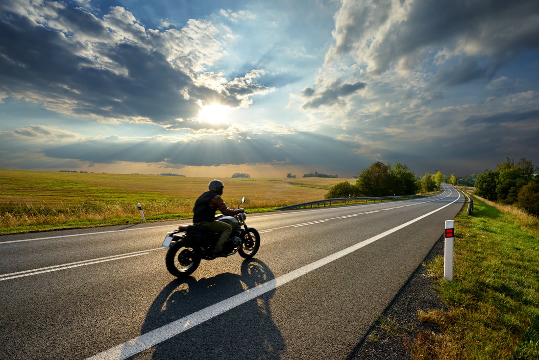 a man riding a motorcycle on the side of a road